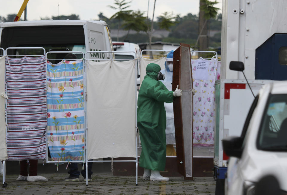 Funeral workers move an empty coffin destined for victims of COVID-19 at the Joao Lucio Hospital in Manaus, Amazonas state, Brazil, Friday, April 17, 2020. (AP Photo/Edmar Barros)