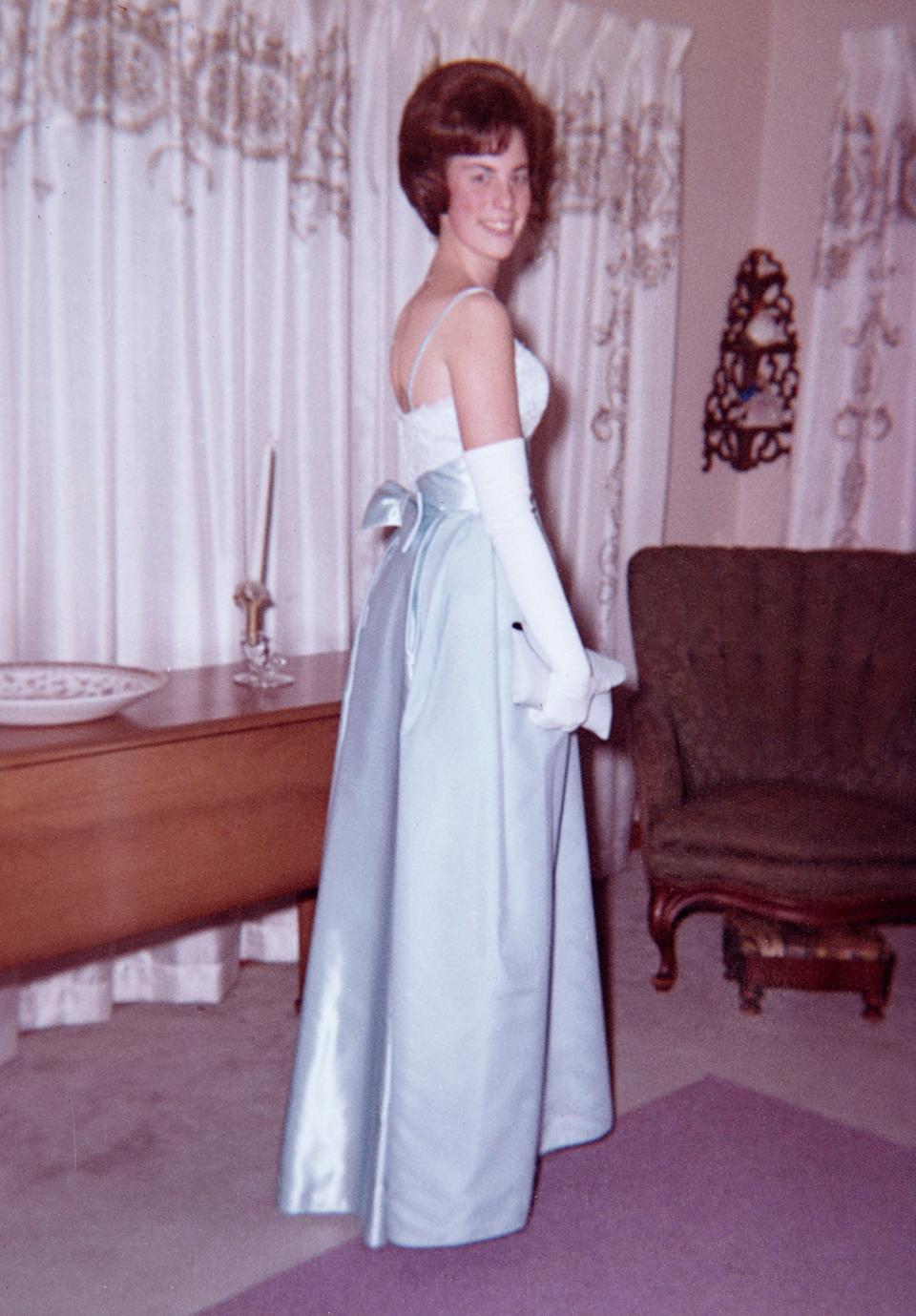 A vintage family photo of teenager in prom dress circa 1964.