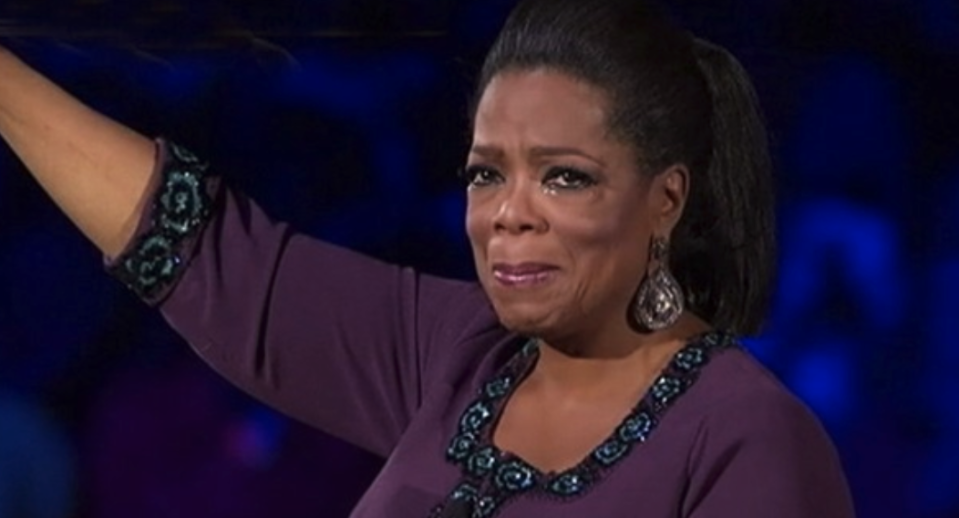 Oprah crying and holding her hand up