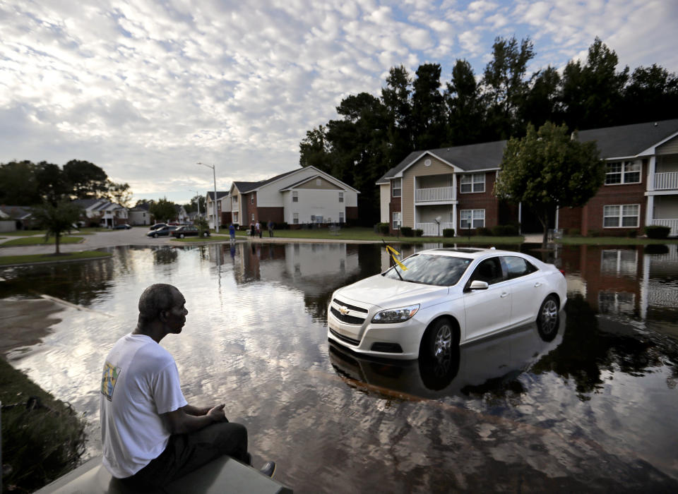 Augustin Dieudomme looks out at the flooded entrance to his apartment complex near the Cape Fear River as it continues to rise in the aftermath of Hurricane Florence in Fayetteville, N.C., Tuesday, Sept. 18, 2018. (AP Photo/David Goldman)