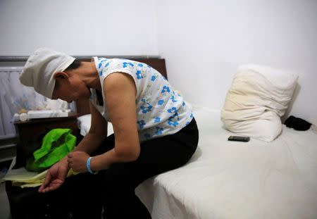 Huang sits on a bed in her room at the accommodation where patients and their family members stay while seeking medical treatment in Beijing, China, June 22, 2016. REUTERS/Kim Kyung-Hoon