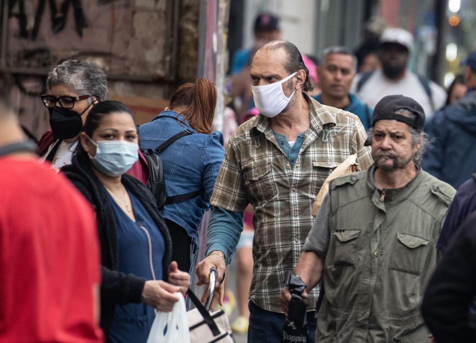 People walk along Fordham Rd. in the Bronx June 8, 2023, on a day when air quality was still deemed unhealthy due to smoke from wildfires in Canada. Bronx residents are particularly at risk as the borough has some of the highest asthma rates in the nation. 