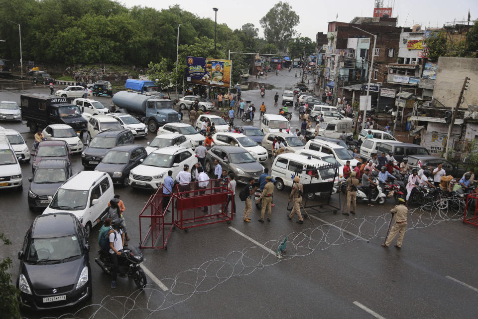 Barricades are set up by Indian police to prevent the moment of vehicles during curfew like restrictions in Jammu, India, Monday, Aug. 5, 2019. An indefinite security lockdown was in place in the Indian-controlled portion of divided Kashmir on Monday, stranding millions in their homes as authorities also suspended some internet services and deployed thousands of fresh troops around the increasingly tense region. (AP Photo/Channi Anand)