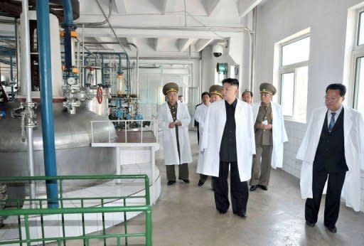 El líder norcoreano, Kim Jong Un (c), visita una fábrica, en una imagen distribuida este 18 de mayo de 2013