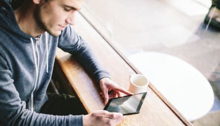 Man in Coffee Shop on Tablet Computer