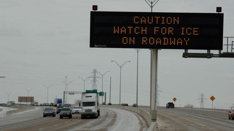 icy highway with alert sign and vehicles