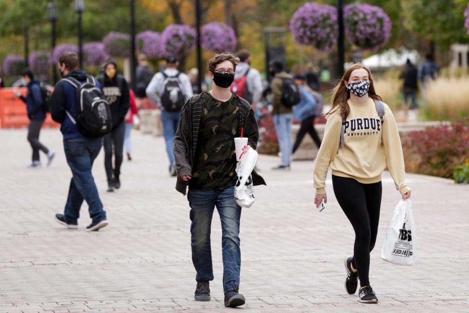 Students walk through Purdue University's campus Oct. 19 in West Lafayette, Ind.
