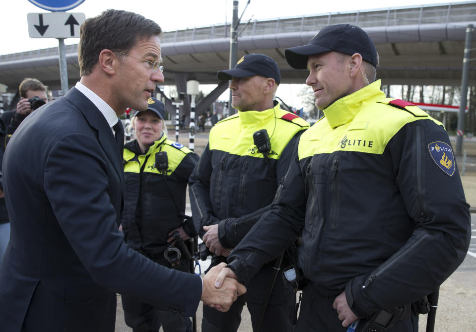 Dutch Prime Minister Mark Rutte expresses his gratitude to Dutch police officers after laying flowers at a makeshift memorial for victims of a shooting incident in a tram in Utrecht, Netherlands, Tuesday, March 19, 2019. A gunman killed three people and wounded others on a tram in the central Dutch city of Utrecht Monday March 18, 2019. (AP Photo/Peter Dejong)