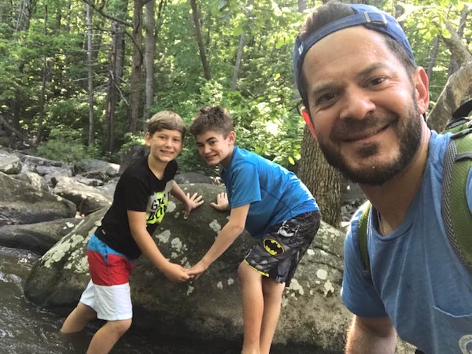 Connor Dobbyn and his brother pose for a photo while hiking with their dad.