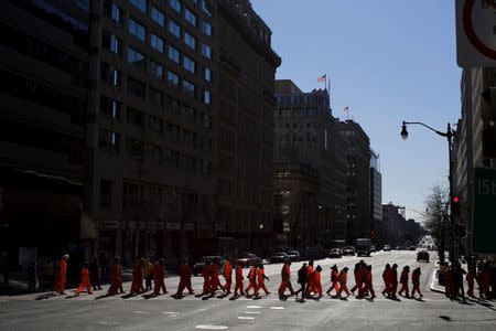 Human right activists dressed as prisoners of Guantanamo Bay march during a rally to demand the closure of Guantanamo prison, near the White House in Washington January 11, 2016. REUTERS/Carlos Barria