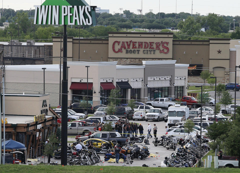 FILE - In this May 17, 2015 file photo, authorities investigate a shooting in the parking lot of Twin Peaks restaurant in Waco, Texas. An attorney for six men arrested after the 2015 shootout between rival biker gangs that left nine people dead and at least 20 injured asked a district court judge Wednesday, June 5, 2019, to assign a special master to supervise the return of items seized from the nearly 200 detained bikers. (AP Photo/Jerry Larson, File)