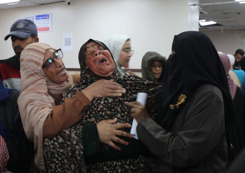 Relatives of Palestinians who were killed in Israeli attacks, mourn as they receive the dead bodies from the morgue of Al-Aqsa Hospital for burial in Deir al Balah. Ali Hamad/APA Images via ZUMA Press Wire/dpa