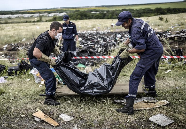 Ukrainian emergency service workers collect bodies of victims of flight MH17 at the crash site near Grabove, on July 20, 2014