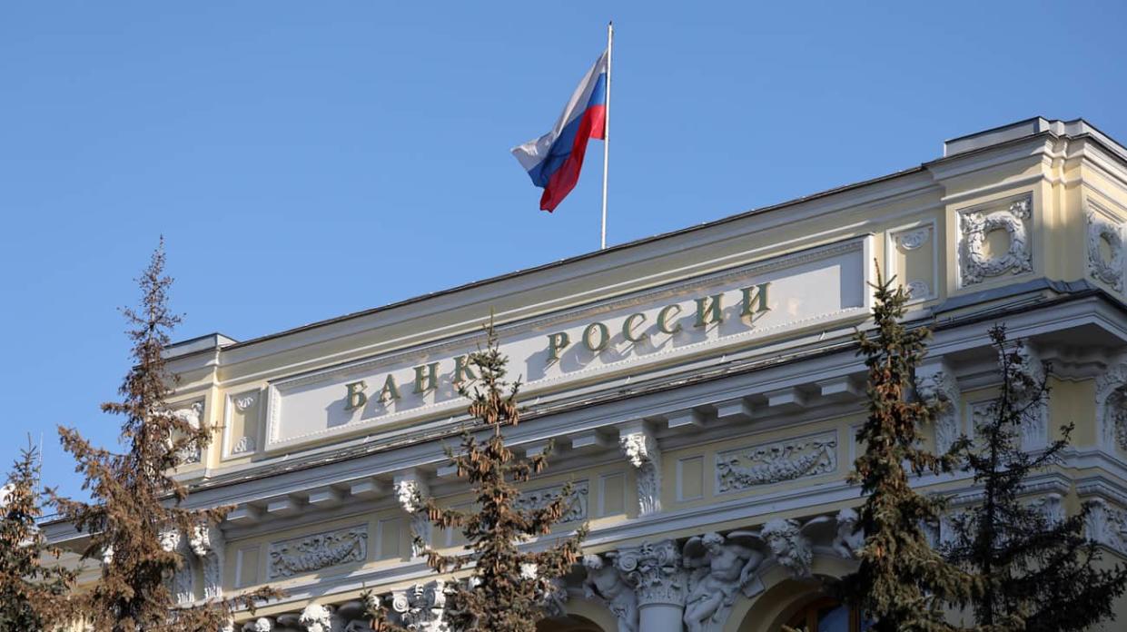 A Russian national flag above the headquarters of Bank Rossii, Russia's central bank, in Moscow, Russia. Photographer: Andrey Rudakov/Bloomberg via Getty Images