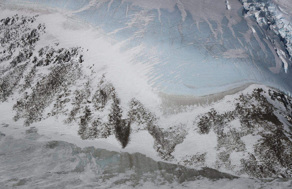 <p>Blue ice (top right) along a ridge can be seen from NASA’s Operation IceBridge research aircraft, in the Antarctic Peninsula region on Oct. 31, 2017, above Antarctica. (Photo: Mario Tama/Getty Images) </p>