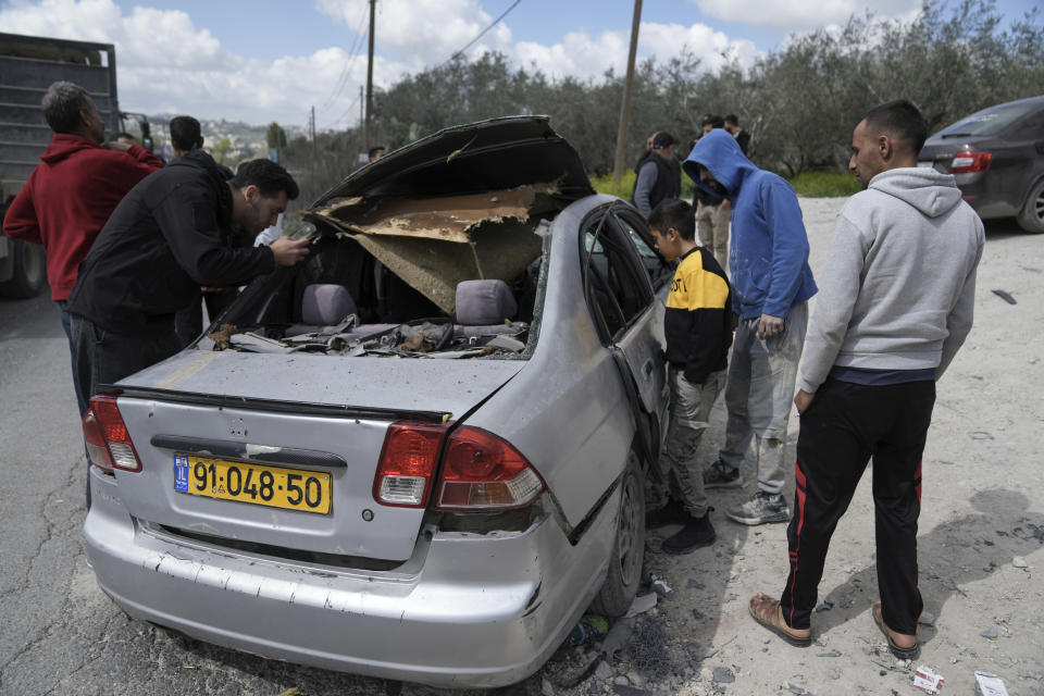 Palestinians inspect a damaged vehicle in which three Palestinian militants were shot and killed by Israeli forces in the West Bank village of Jaba, near Jenin, Thursday March 9, 2023. Palestinian officials say at least three Palestinian militants were killed after Israeli security forces entered a village in the northern occupied West Bank. The Israeli Police said Thursday that troops carried out a raid in Jaba to apprehend suspects wanted for attacks on Israeli soldiers in the vicinity. The three militants killed included the head of a local Palestinian militant group. (AP Photo/Nasser Nasser)