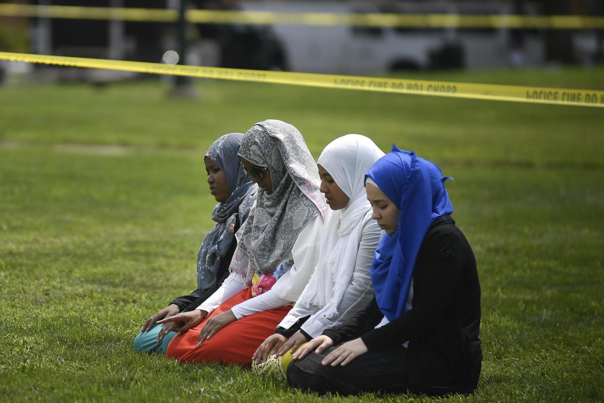 A group of women take part in afternoon prayers led by Dar Al Farooq Islamic Center Executive Director Mohamed Omar outside the police tape surrounding the center: Aaron Lavinsky/Star Tribune via AP