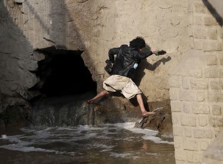 A man runs away during a police round up of suspected drug addicts in Kabul, Afghanistan December 27, 2015. REUTERS/Ahmad Masood