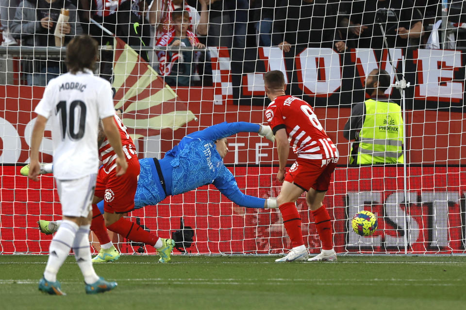 Real Madrid's goalkeeper Andriy Lunin dives but fails to save the goal from Girona's Castellanos during the Spanish La Liga soccer match between Girona and Real Madrid at the Montilivi stadium in Girona, Spain, Tuesday, April 25, 2023. (AP Photo/Joan Monfort)