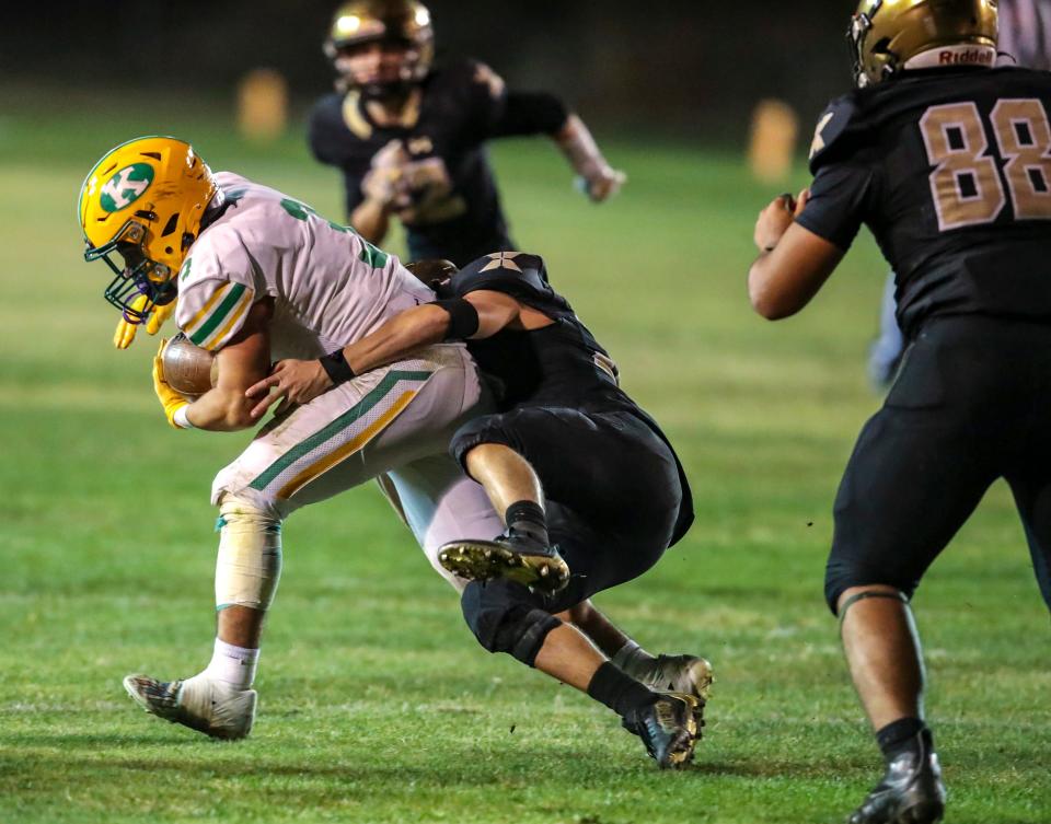 Kennedy's Rider Street (3) is wrapped up by Xavier Prep's Canyon Pensis (33) during the third quarter of their second-round playoff game at Xavier College Preparatory High School in Palm Desert, Calif., Friday, Nov. 10, 2023.