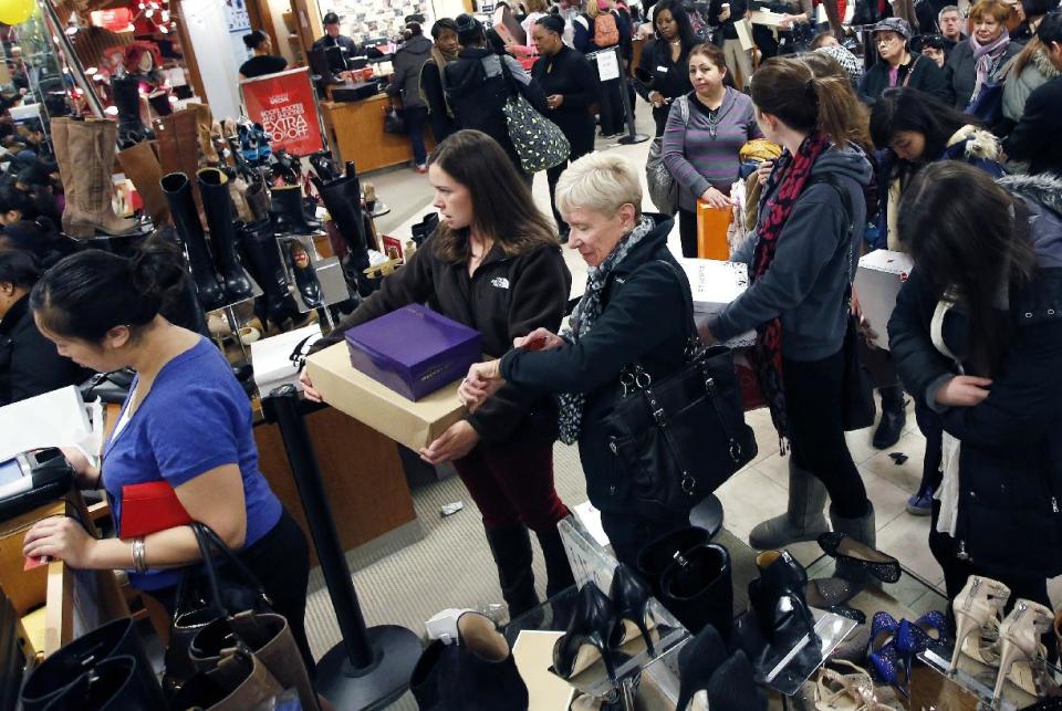 Cheryl Shedden, center right, of Beavercreek, Ohio, checks her watch while waiting in the checkout line with her daughter Catie Smoot, center left, of Providence, R.I., at Macy's in downtown Boston, Friday, Nov. 23, 2012. Black Friday, the day when retailers traditionally turn a profit for the year, got a jump start this year as many stores opened just as families were finishing up Thanksgiving dinner. (AP Photo/Michael Dwyer)