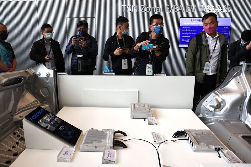 People take photos of electric vehicle components on display during the Foxconn's annual Tech Day in Taipei,