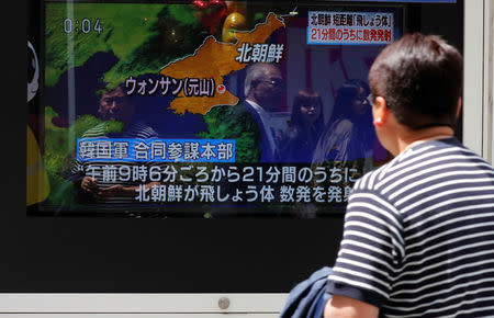 A man watches a television screen showing a news report on North Korea firing several short-range projectiles from its east coast, on a street in Tokyo, Japan May 4, 2019. REUTERS/Kim Kyung-Hoon