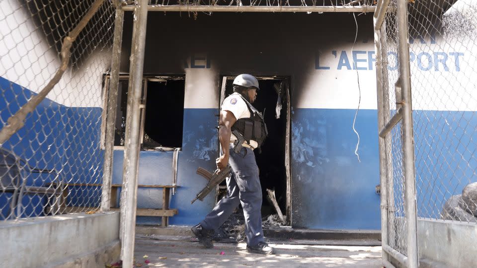A law enforcement officer at a police station set on fire by armed gangs in Port-au-Prince, Haiti, on March 5, 2024. - Odelyn Joseph/AP