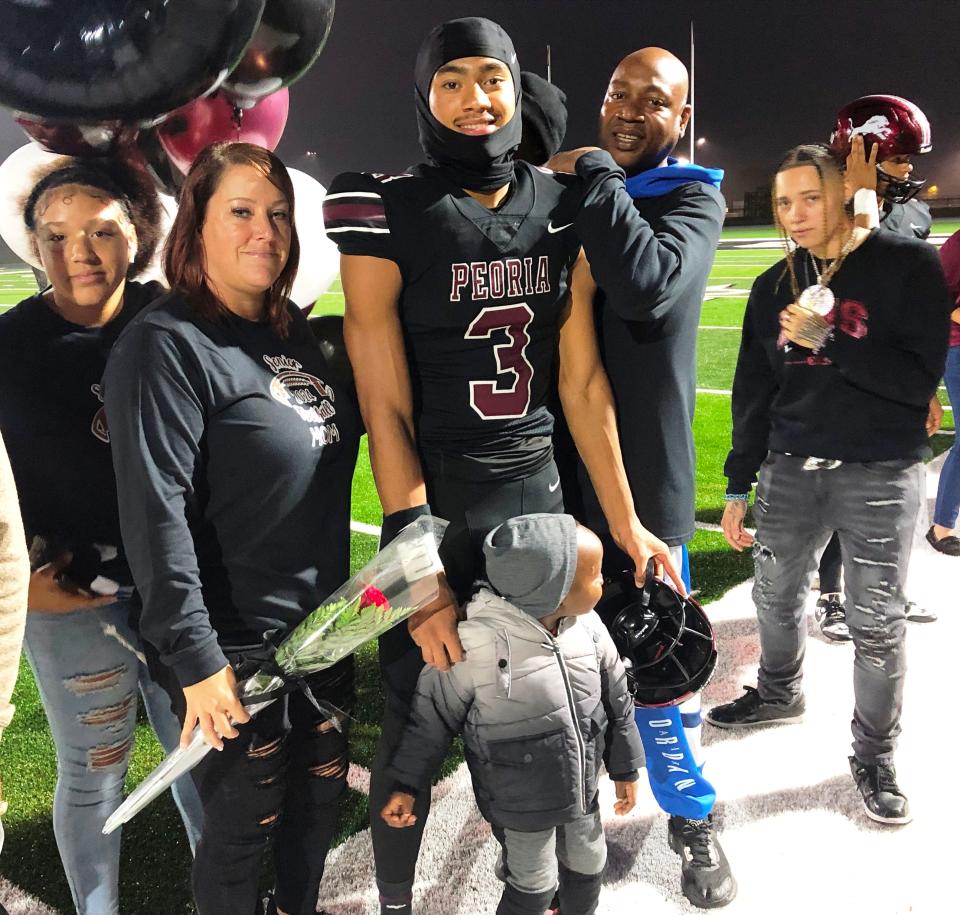 Peoria High receiver Jaivyn Moore and his family -- including 2-year-old little brother, Knowledge -- on the Lions sideline during senior ceremonies before a 62-41 win over Normal West at Peoria Stadium on Friday, Oct. 13, 2023.