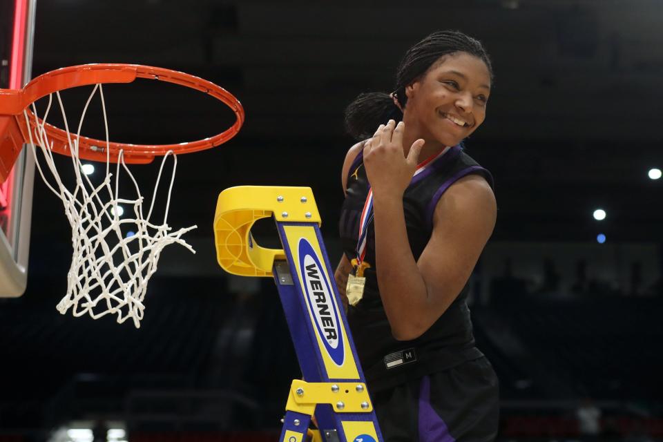 Reynoldsburg's Imarianah Russell smiles toward teammates as she cuts the net after a 63-56 overtime win against Mason in the OHSAA Division I state championship game March 12 at UD Arena in Dayton.