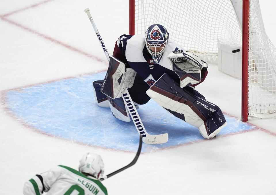 Colorado Avalanche goaltender Alexandar Georgiev, back, deflects a shot from Dallas Stars center Tyler Seguin in the third period of an NHL hockey game Sunday, April 7, 2024, in Denver. (AP Photo/David Zalubowski)