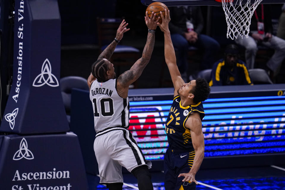 Indiana Pacers guard Malcolm Brogdon, right, blocks the shot of San Antonio Spurs forward DeMar DeRozan, left, during the first half of an NBA basketball game in Indianapolis, Monday, April 19, 2021. (AP Photo/Michael Conroy)