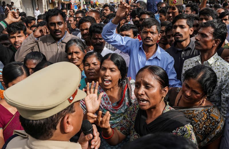 Demonstrators argue with a police officer during a protest against the alleged rape and murder of a 27-year-old woman in Shadnagar