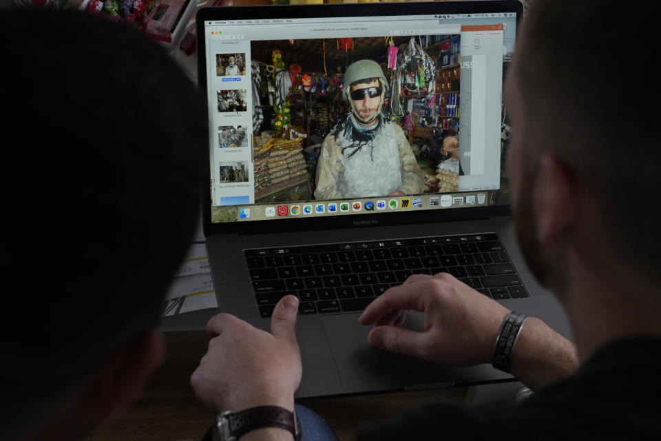 U.S. Army veteran Spencer Sullivan, right, and Abdulhaq Sodais, who served as his translator in Afghanistan, left and seen on the computer screen center, talk when looking at images taken in Afghanistan, at Sodais' apartment in Bremen, Germany, Friday, Aug. 13, 2021. Sullivan is among scores of U.S. combat veterans working on their own to rescue the Afghans, like Sodais, who served alongside them. (AP Photo/Peter Dejong)