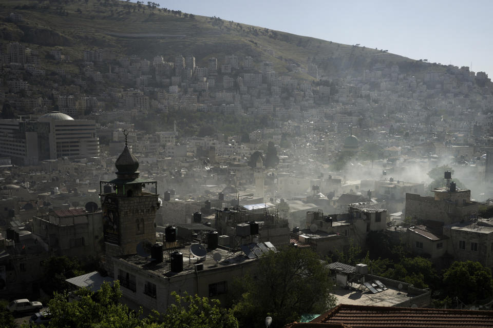 Smoke rises during a raid by Israeli security forces in the occupied West Bank city of Nablus, Thursday, May 4, 2023. The Israeli military says it has killed three Palestinians wanted for an attack last month on a car near a Jewish West Bank settlement that killed a British-Israeli mother and two of her daughters. The military says a fierce gunbattle erupted when the army entered the heart of the flashpoint city of Nablus early Thursday. (AP Photo/Majdi Mohammed)