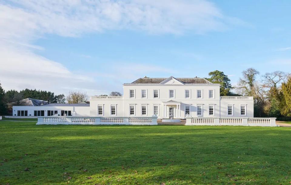 a large white house with a lawn in front of it