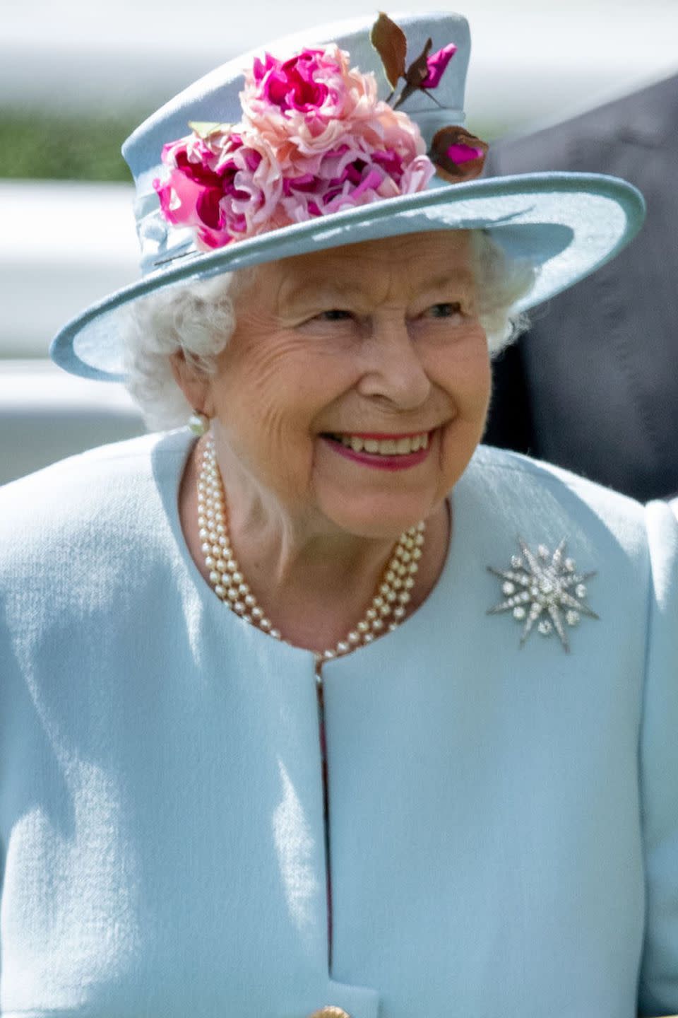 <p>Queen Elizabeth II went for a powder blue structured hat with fuschia flowers.</p>
