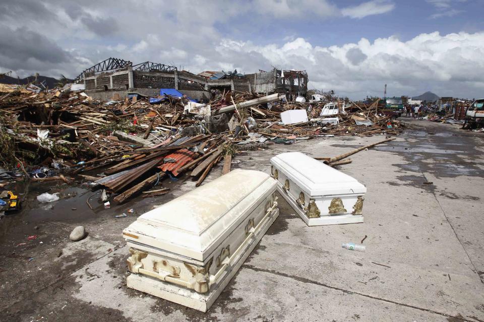 Empty coffins lie on a street near houses damaged after super Typhoon Haiyan battered Tacloban city