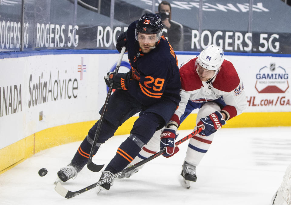 Edmonton Oilers' Leon Draisaitl (29) and Montreal Canadiens' Corey Perry (94) compete or the puck during the third period of an NHL hockey game Wednesday, April 21, 2021, in Edmonton, Alberta. (Jason Franson/The Canadian Press via AP)