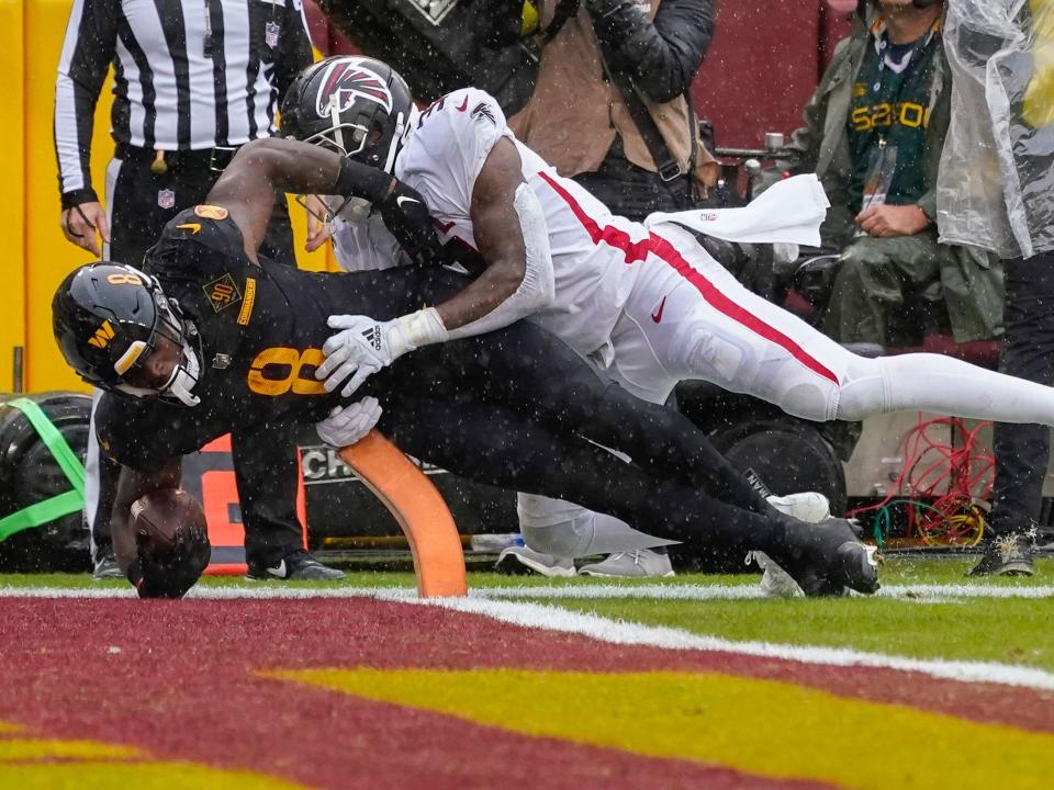 Brian Robinson Jr. dives for the end zone against the Atlanta Falcons.