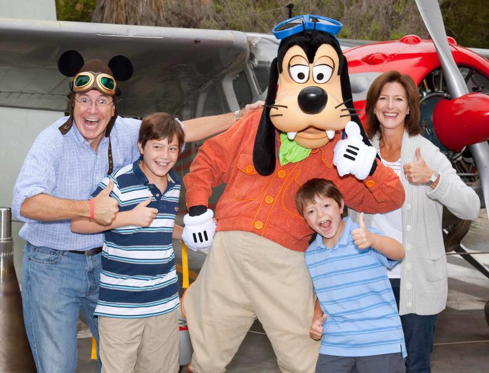 Stephen Colbert, wife Evelyn Colbert and sons Peter Colbert and John Colbert pose with Goofy outside the Soarin Over California attraction at Disney California Adventure park in on August 28, 2010 in Anaheim, California