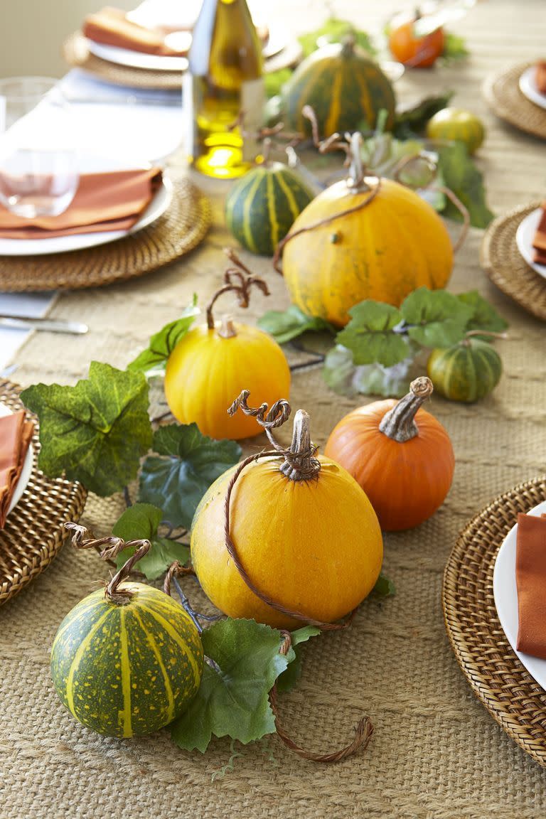 <p>Fill out a row of decorative gourds by weaving in a faux ivy garland. Take this two-step project to the next level by curling wire vines around pumpkin stems.</p>