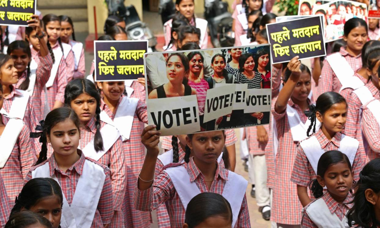 <span>College students hold placards to create awareness for citizens to vote, in Varanasi, ahead of India's 2024 general election.</span><span>Photograph: Niharika Kulkarni/AFP/Getty Images</span>