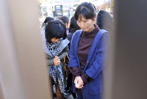 Mothers pray for their children's success in the College Scholastic Ability Test, a standardised exam for college entrance, outside a high school in Seoul on November 10, 2011