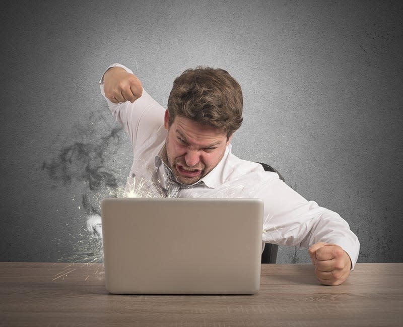 A man punching a computer