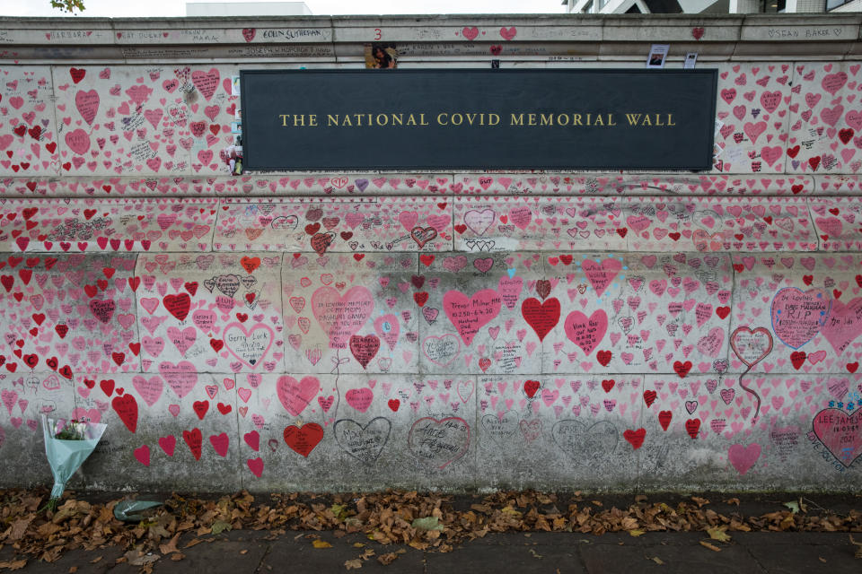 <p>A bouquet of flowers is pictured in front of the National Covid Memorial Wall on the South Bank of the River Thames on 15th October 2021 in London, United Kingdom. The National Covid Memorial Wall is a public mural comprising thousands of red and pink hearts painted by volunteers in order to commemorate the victims of the COVID-19 pandemic in the United Kingdom. (photo by Mark Kerrison/In Pictures via Getty Images)</p>
