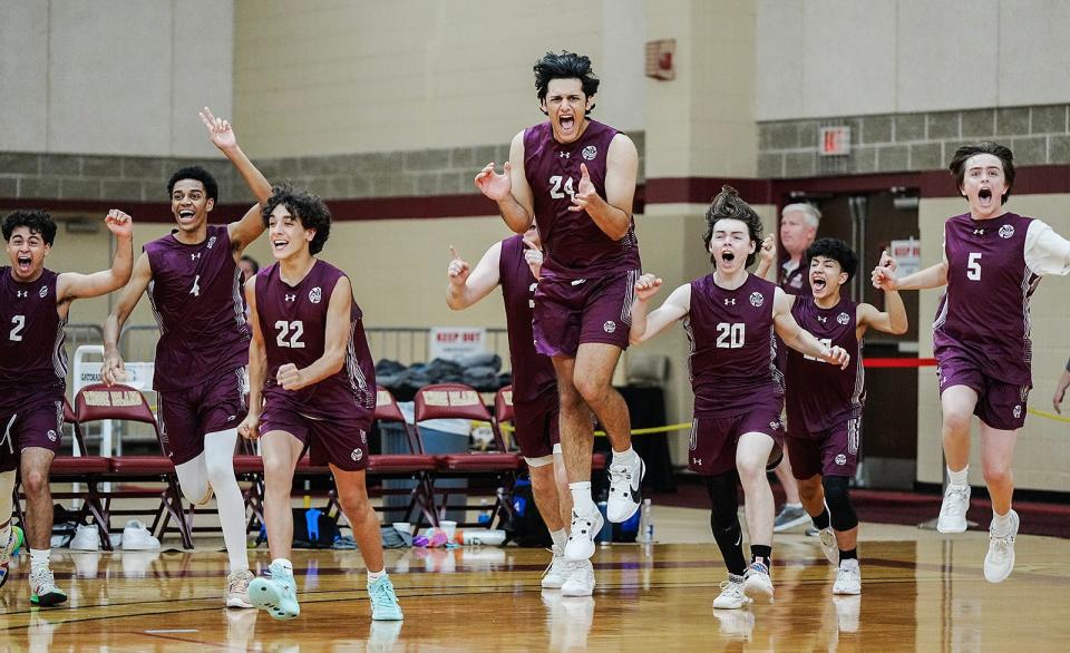 Players on the La Salle bench rush to the floor to celebrate with their teammates at the end of the match.