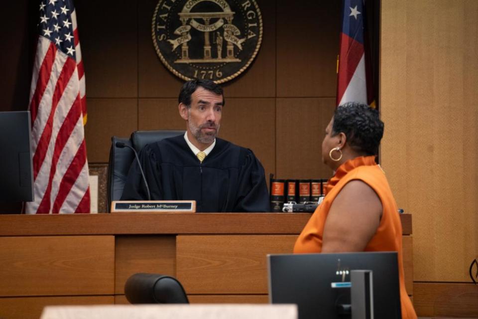 Judge Robert McBurney receives documents from the county court clerk, Che Alexander, on Monday.