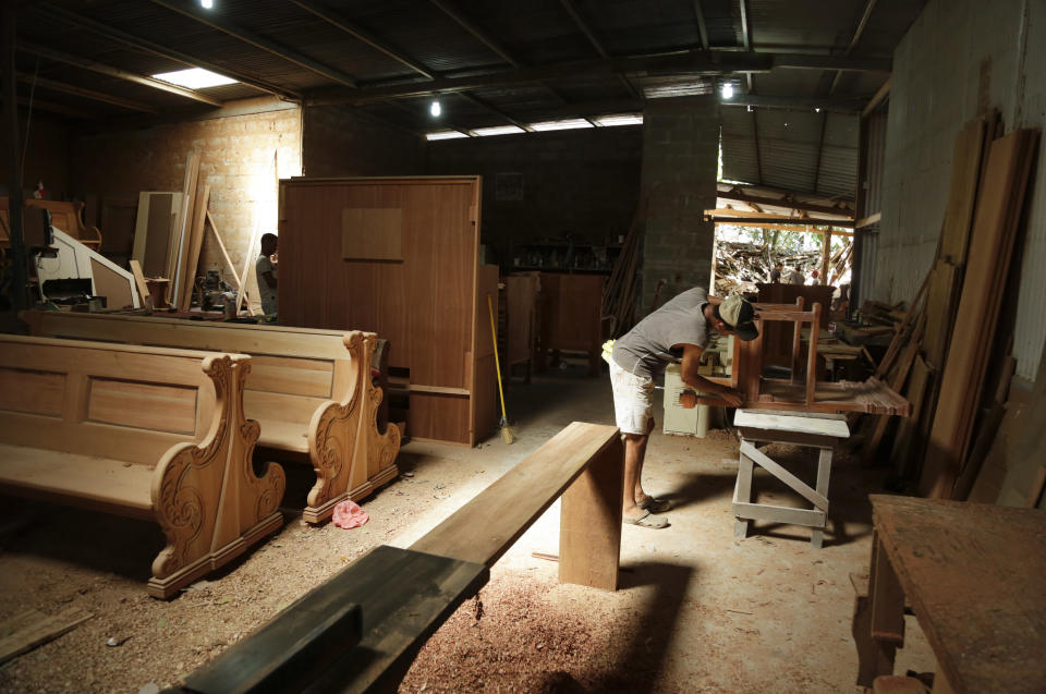 A worker sands a wooden chair that will be used by Cardinals and Bishops during Pope Francis' Mass on World Youths Day, at Hernan Guardia's carpentry workshop where the Pope's chair is also being built in Los Pozos, Panama, Saturday, Jan. 12, 2019. The Argentine pontiff visit Panama Jan. 23-27. (AP Photo/Arnulfo Franco)