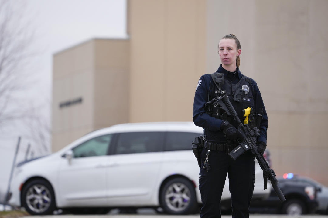 A female police officer holding a semiautomatic rifle outside Perry High School in Perry, Iowa.